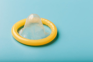 Opened condom on a blue background. Use of protection to reduce the likelihood of sexually...