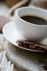 Cup of coffe with milk and chocolate cookies on warm wool blanket