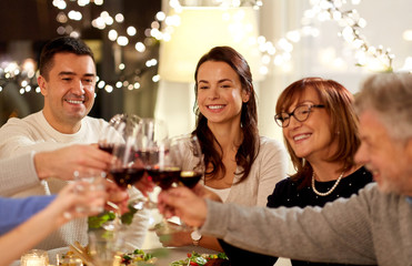 celebration, holidays and people concept - happy family having dinner party, drinking red wine and toasting at home