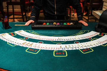 Professional croupier during cards shuffle in the casino
