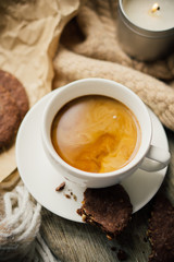 Cup of coffe with milk and chocolate cookies on warm wool blanket