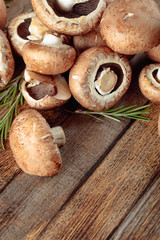 Fresh brown mushrooms champignon on a old wooden table.
