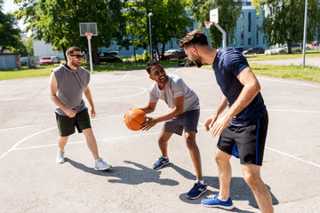 sport, leisure games and male friendship concept - group of men or friends playing street basketball