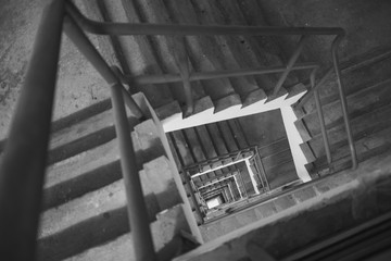 Abstract architecture background, square concrete stairway perspective, looking down in a stairwell, black and white photo