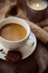 Cup of coffe with milk and chocolate cookies on warm wool blanket