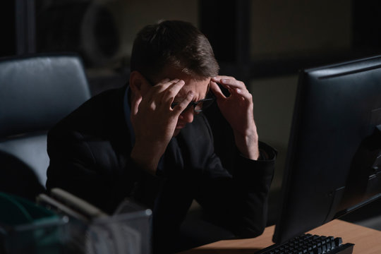 Stressed businessman working in the office during overtime period. overwork and deadline concept.