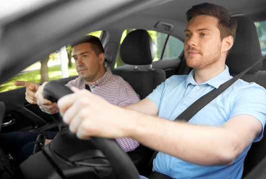 driver courses and people concept - car driving school instructor teaching young man to drive