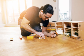 Craftsman corrects imperfections in the parquet with a repair set