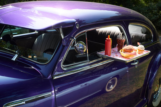 Typical American fast food on tray at vintage car, Chevrolet Fleetline