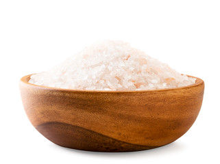 Pink salt in a wooden plate close-up on a white background.