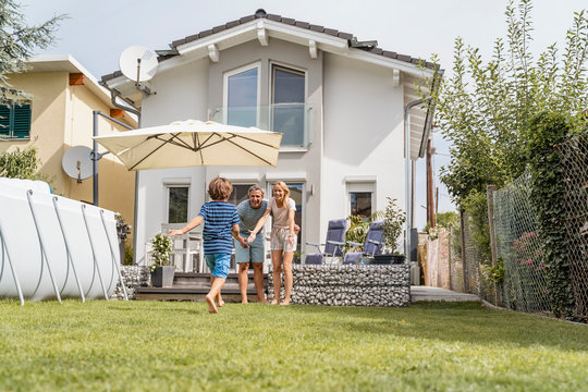 Boy running in garden towards parents