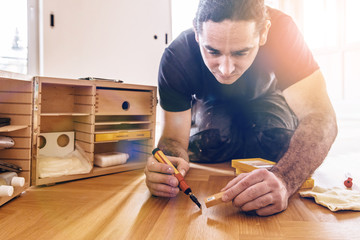 Craftsman corrects imperfections in the parquet with a repair set