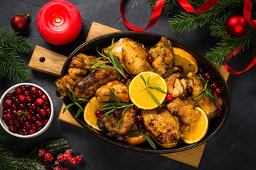 Fototapeta na wymiar Christmas food - roasted chicken with orange on dark table.