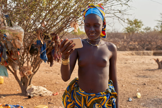 Young Mucubal woman checking her smartphone, Tchitundo Hulo, Virei, Angola