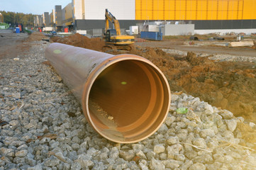 A plastic pipe lying on the territory of the construction site for the needs of water disposal.