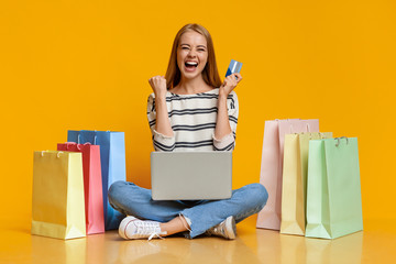 Beautiful girl excited after successful online shopping.