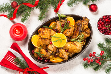 Fototapeta na wymiar Christmas food - roasted chicken with orange on white table.