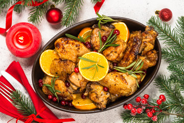 Christmas food - roasted chicken with orange on white table.