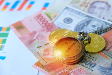 Business and Financial Concept. Multiple Currencies Banknote on graph and chart with classic pocket watch