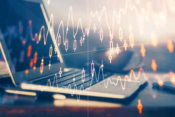 Financial graph colorful drawing and table with computer on background. Multi exposure. Concept of international markets.