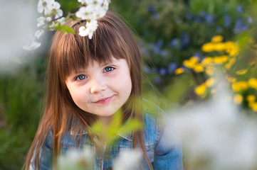 Little girl in garden, under the cherry tree. Spring petal's .