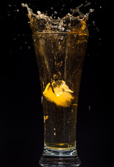 Glass of beer with foam on a black background in the dark