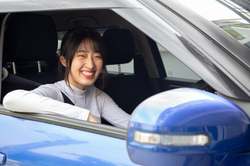 Happy Asian women driving a car and smile with glad positive expression during the drive to work office in workday