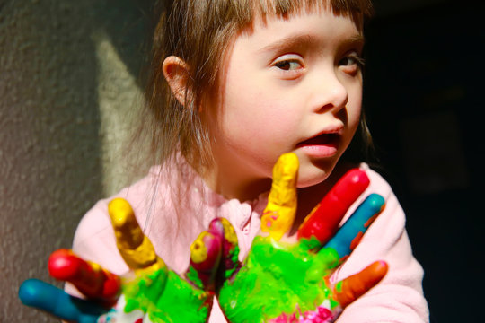 Cute little kid with painted hands isolated on the black