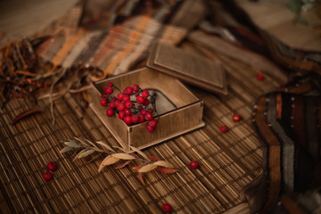Naklejka na ściany i meble Gift, autumn leaves and berries on wooden background
