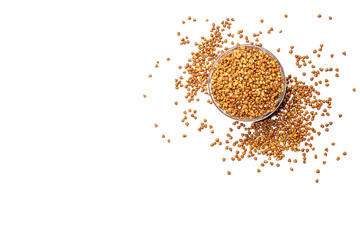 Buckwheat in a glass bowl on the left side, buckwheat groats on a white background top view.