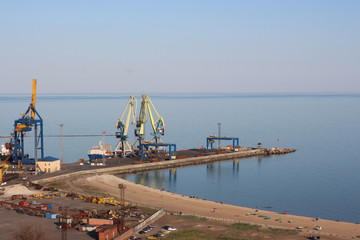 Fototapeta na wymiar Seaport with large industrial cranes.