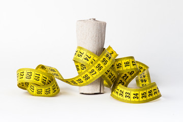 Measuring Tape wrapped around a roll of toilet paper diet concept
