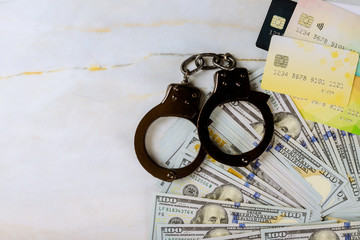 Financial crimes credit cards and dollar bills handcuffed stealing credit card money and fingerprint record US dollar banknotes money cash corruption