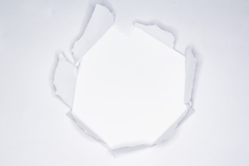 Ripped hole in the paper with torn edges
