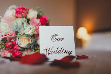 Obraz premium Box with the inscription our wedding lies on the bed with a bouquet of brides