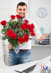 Adult male is presenting flowers and gift