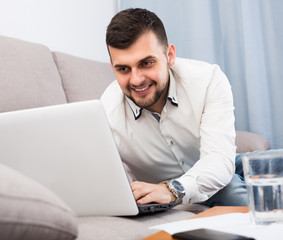 Man with laptop is enjoying booking hotel online