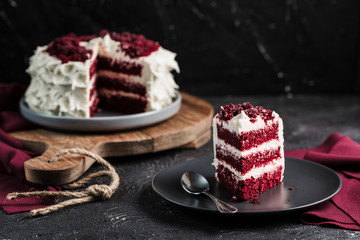 Red velvet cake on dark background, close-up side view. Sweet dessert for the holiday.