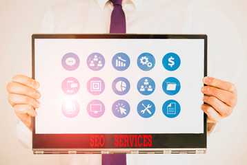 Handwriting text Seo Services. Conceptual photo suite of techniques and procedures to surge website visibility Male human holding thick textured cardboard of business promotion concept