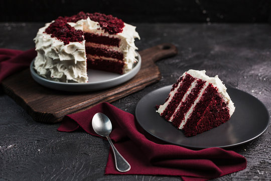 Red velvet cake on dark background, close-up side view. Sweet dessert for the holiday.