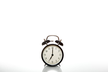 black vintage alarm clock time 7 hours isolated on white background