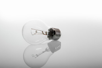 Energy saving and incandescent light bulb lies on gray background