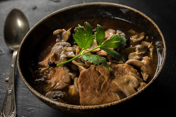 Stewed pork chop in a bright mushroom sauce.