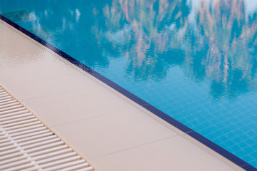 Reflection of palm trees in the pool water. Summer holidays, vacation and tourism.