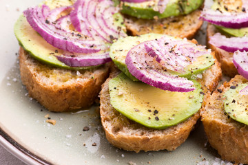 Sandwich with fresh avocado and onion on a plate