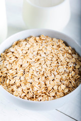 Rolled oats or oat flakes in wooden bowl