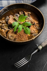 Stewed pork chop in a bright mushroom sauce.