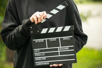 Man with clapperboard outdoor
