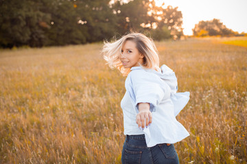 Young active woman in shirt walking outdoors at sunset. Turn around