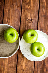Healthy green food with apples on plates wooden background top view mock up